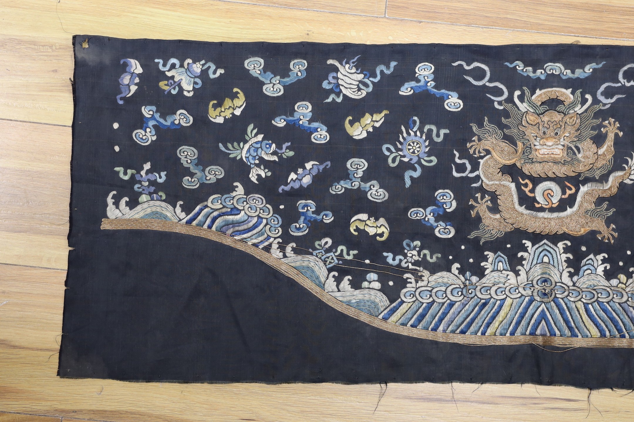 A Chinese late 19th century embroidery of a dragon, probably from a Chinese robe or hanging 37x105cm